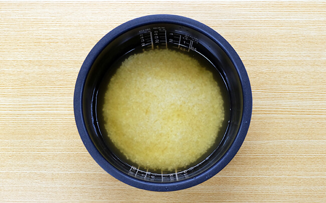 炊飯器へ米と漬液と水 たけのこときゅうりの炊き込みご飯